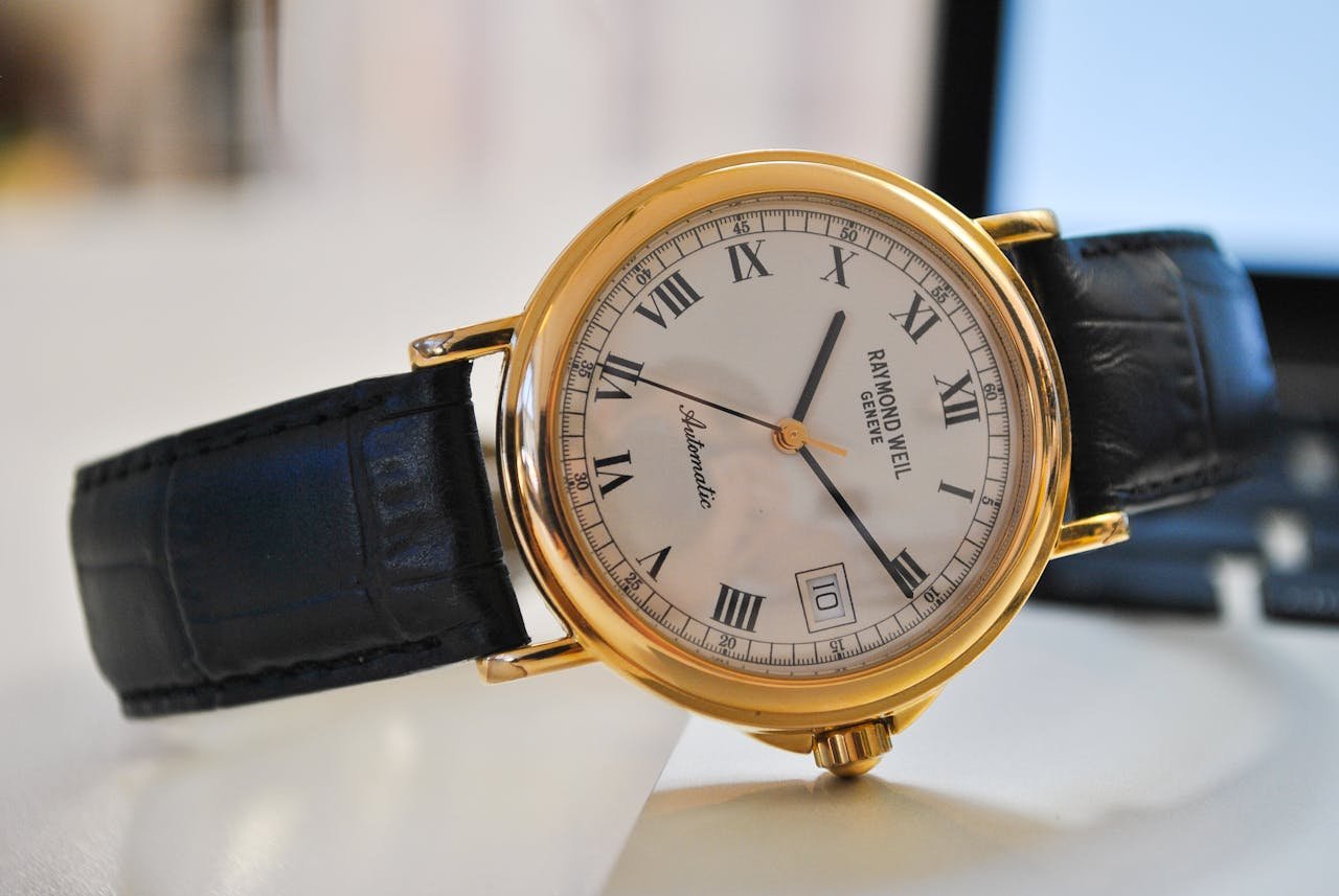 Close-up of a classic gold wristwatch with a black leather strap, showcasing time precision and elegance.
