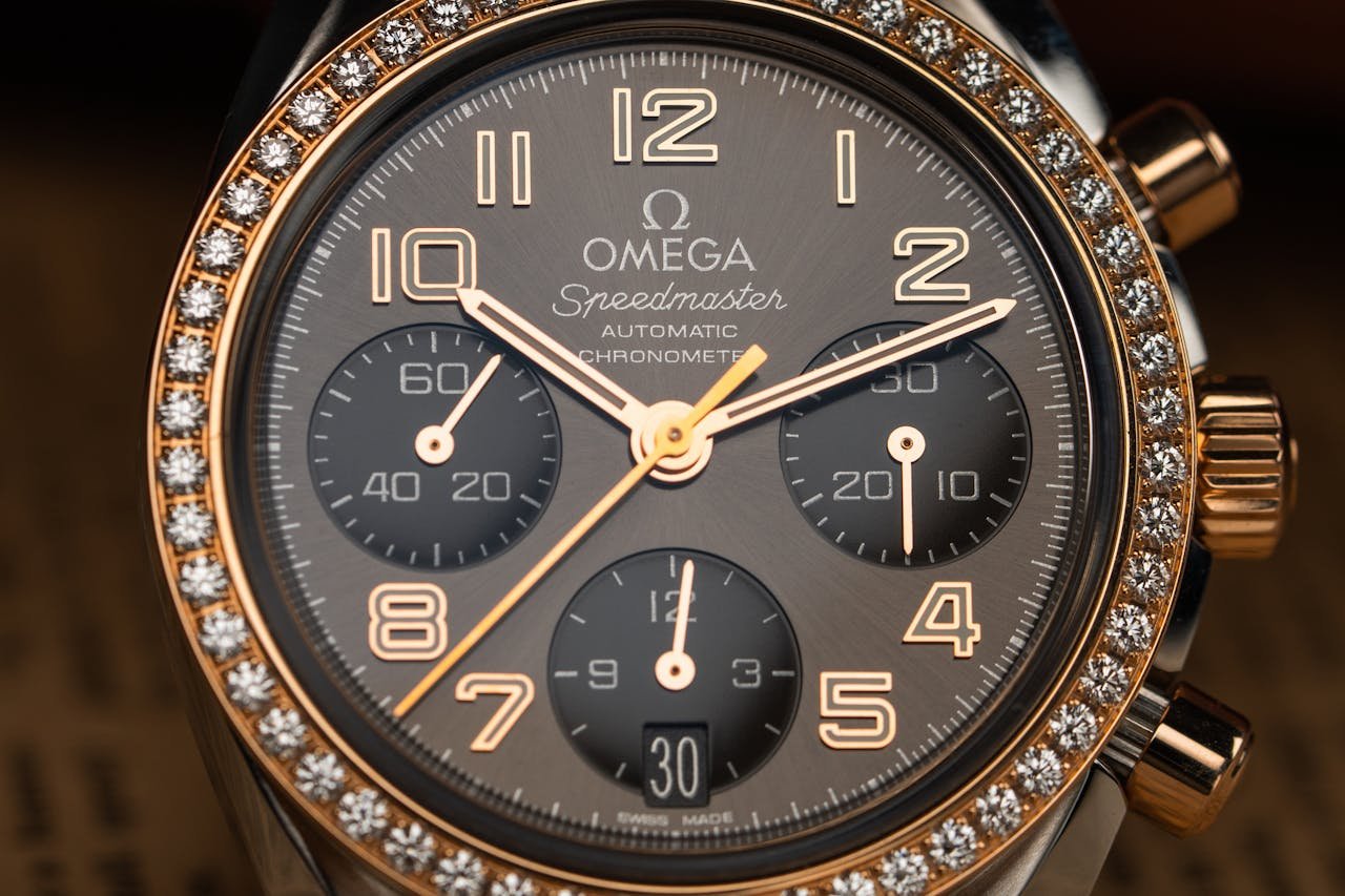 Close-up of a luxurious Omega Speedmaster watch with diamond bezel and chronograph features.