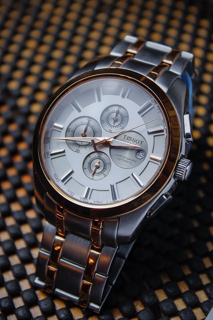 Detailed close-up of a luxurious Tissot wristwatch with metallic finishes.